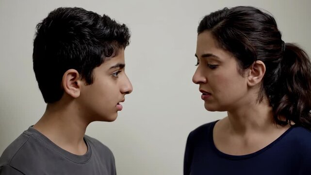 An angry mother has a serious and confrontational argument with her teenage son. The parent is scolding the child, showing family conflict and discipline. Parenting and teenage relationship issues