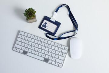 Modern Office Desk Setup With Keyboard, Mouse, Plant, And ID Badge