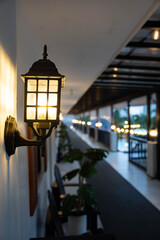 an antique lamp lit in the hallway at night time