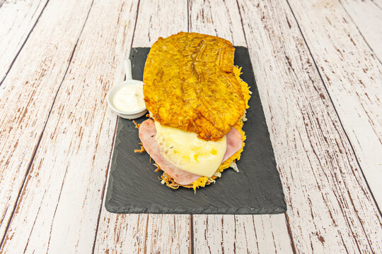 Artisanal patacones topped with shredded baked pork, red cabbage slaw, and spicy mango salsa