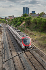Urban track section with side acoustic screens, LED lighting, and controlled vegetation between the two directions of traffic