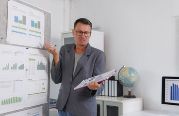 Mature man discussing business data performance with charts