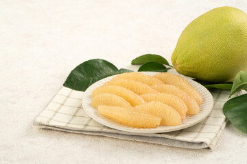 Fresh pomelo fruit with leaf on white table background.
