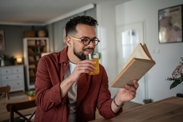 Young man reading book relaxing at home