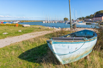 Marina at Norsminde, village on the Baltic Sea coast near Aarhus, Denmark. An old fishing boat in foreground.