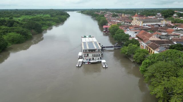 Aerial view of the picturesque colonial town Santa Cruz de Mompox (Momp&oacute;s) in the Bol&iacute;var Department in Colombia, flying over a river cruise ship on the legendary Magdalena river