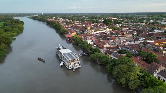 Aerial view of the picturesque colonial town Santa Cruz de Mompox (Momp&oacute;s) in the Bol&iacute;var Department in Colombia, showing a river cruise ship on the legendary Magdalena river in the afternoon light