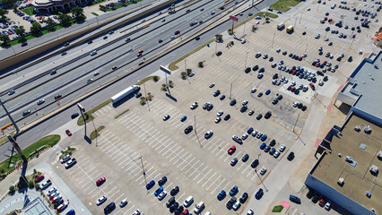 Busy NE Loop 820 corridor in North Richland Hills, Texas showing large retail outdoor parking lots, rooftop HVAC systems, car dealership, multilane dense traffic with bridge-over-underpass