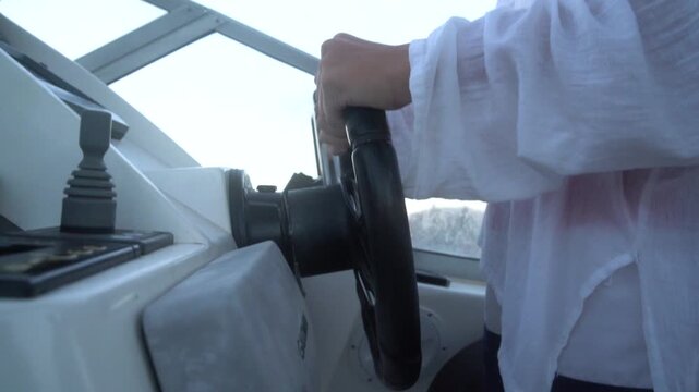 Boating steering helm Close-up shot of woman driving a motorboat on the open water during travel vacation