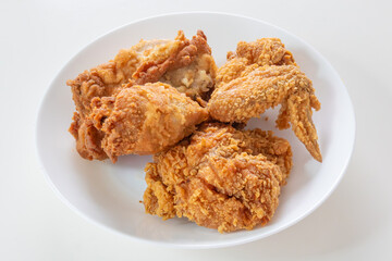 Crispy fried chicken in white plate on wood table