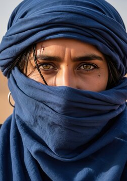 Close up portrait of beautiful tuareg woman with intense green eyes wearing blue headscarf