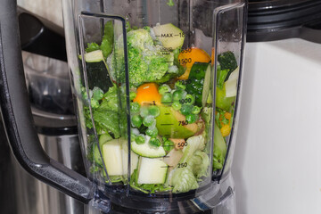 Various vegetables and fruits for making smoothie in blender bowl