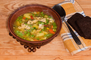 Vegetable soup serving with meat in bowl on rustic table