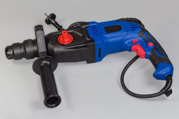 Electric rotary hammer drill on a gray background