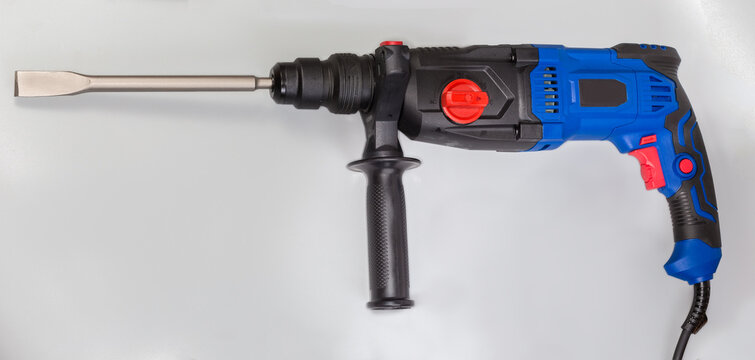 Electric rotary hammer drill with inserted flat chisel, side view
