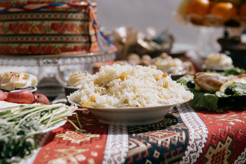 A large plate of pilaf with rice and raisins on a festive table