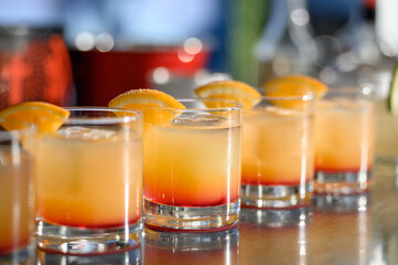 Close-up of tequila sunrise or tropical shot cocktails