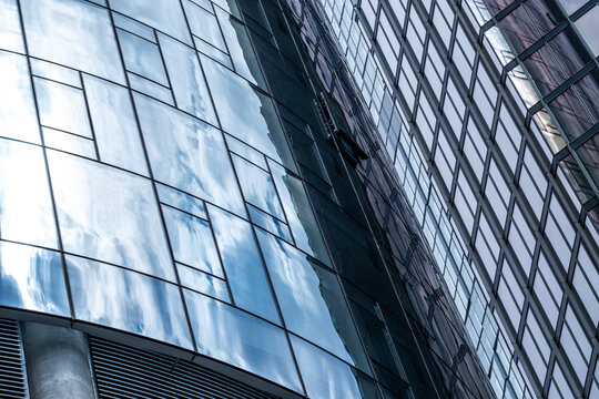 Modern curved glass building with reflective surfaces showing smooth forms, dynamic lines, and abstract play of transparency and depth