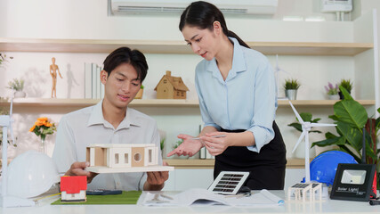 Sustainability in Architecture. Young professionals discussing eco-friendly building design.