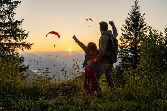 Family hiking in mountains at sunset celebrating outdoor adventure