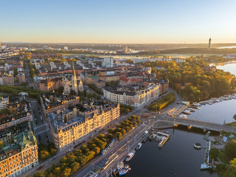 Aerial view of golden light bathing the cityscape, highlighting the spires of churches and the winding waterways, Stockholm, Stockholm County, Sweden.
