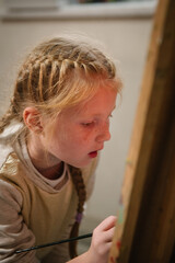 Girl enjoys painting in workshop. Art lesson. Education and learning concept. Child draw a picture in art class. School kid drawing with brush landscapes on easel. Mix and combine colors.