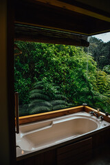 Fotografía de una bañera de madera con vistas al bosque en Coromandel Town, Waikato, en Nueva Zelanda.