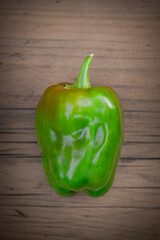 Single Green Bell Pepper on a Wooden Table