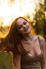Fototapeta premium Young Woman Enjoying Sunshine in Grass Field Backlit