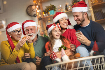Cheerful multi-generation family having fun while eating Christmas cookies