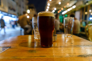 View of a pint of Guinness beer at a table outdoors at night in Paris France