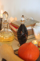 Lit candles, cookies, chocolate, nuts, tea, wine, pumpkins, books, reading glasses and autumn leaves on the table. Autumnal hygge at home. Selective focus.