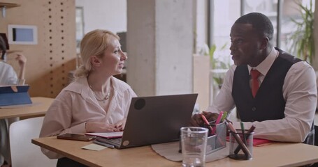Multicultural business team collaborating on a project in a modern office. They are discussing strategies and analyzing data on a laptop. - Powered by Adobe