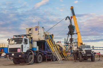 Fototapeta premium The Northern gas field. Summer. Installation for lowering a flexible pipe into a well. Equipment for testing and development of a gas well