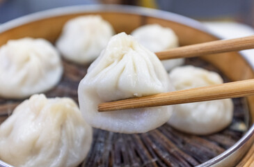 Pick up a xiaolongbao from the steamer with chopsticks