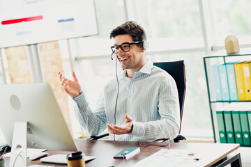 Confident businessman wearing headset having a virtual meeting in a modern office environment with bright decor