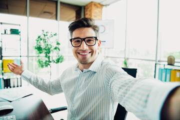 Professional businessman smiling confidently in a modern office setting representing enthusiasm and workplace success