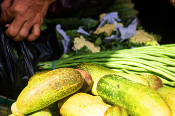 Fresh cucumbers and long beans at vibrant farmers market, perfect for healthy eating campaigns and summer food promotions, showing natural produce and a sustainable lifestyle