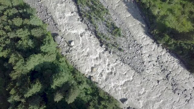 Drone shot of the Parvati River flowing between mountains at Kasol, Himachal Pradesh, India. Scenic view of the river during winter surrounded by natural mountain landscapes.