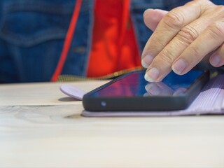 A close up of a lady's finger swiping across the screen of a smartphone.
