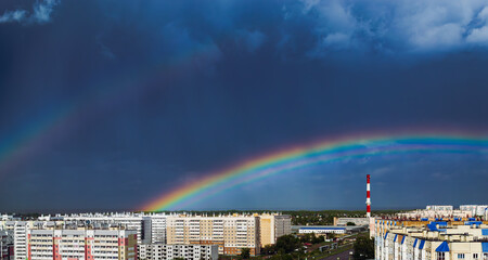Double rainbow over city buildings after rain