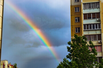 Rainbow between apartment buildings in city