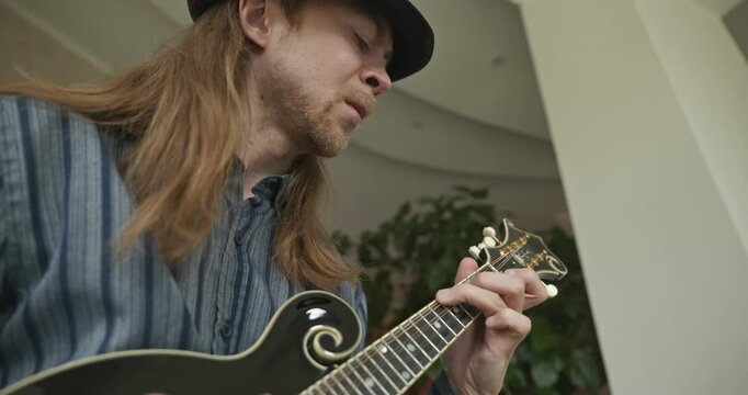 Male Musician Plays Mandolin. Caucasian Man Enjoys Playing Music 4K 10-bit