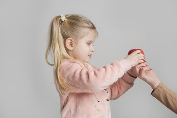 Mother Offering Apple to Cute Little Girl – Healthy Snack and Childhood Concept