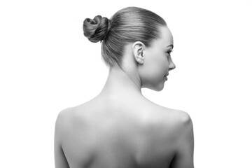 Studio portrait of a woman with elegant bun hairstyle viewed from the back. Minimalist concept of beauty, healthy skin, and natural femininity on white background.
