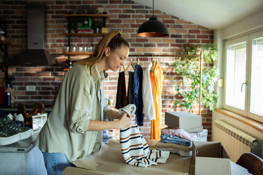 Young woman preparing online orders at home
