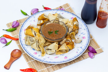 A savory plate of traditional Indonesian Batagor, fried dumplings and tofu served with a rich peanut sauce and fresh chili