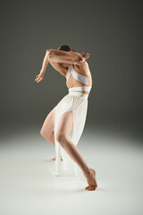 Elegant performance of ballet by a beautiful young woman in a simple studio setting