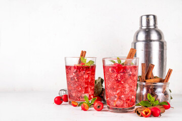 Sweet and sour fall seasonal alcohol hawthorn or rosehip cocktail, autumn berry mojito or margarita, spicy alcoholic drink with hawthorn or rosehip liquor, cinnamon, int crushed ice