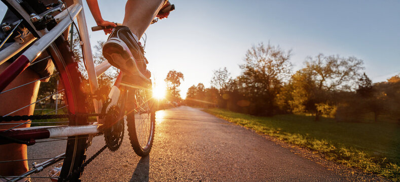riding bicycle outdoors, closeup of foot on pedal low angle, cycling background banner